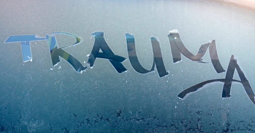 window fogged up with the word trauma written on it with a finger